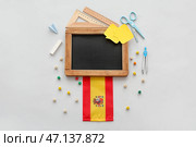 Доска с канцелярскими принадлежностями и флагом Испании на сером фоне. Стоковое фото, фотограф Pixel_shot / Фотобанк Лори
