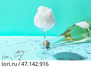 Бокал со сладкой ватой и бутылка шампанского на синем фоне. Стоковое фото, фотограф Pixel_shot / Фотобанк Лори