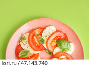 Тарелка вкусного салата капрезе на зеленом фоне крупным планом. Стоковое фото, фотограф Pixel_shot / Фотобанк Лори
