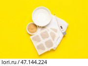 Горчичники с миской с водой, термометром и полотенцем на желтом фоне. Стоковое фото, фотограф Pixel_shot / Фотобанк Лори