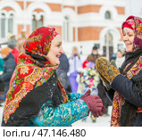 Женщины с повязанными Павловопосадскими яркими цветными платками на головах. Празднование Масленицы на территории Кафедрального собора в честь Преображения Господня. Бердск, Новосибирская область, Западная Сибирь, Россия. Редакционное фото, фотограф Евгений Мухортов / Фотобанк Лори