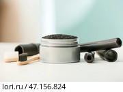 Баночка с зубным порошком с активированным углем, щетки и бамбуковые палочки на столе. Стоковое фото, фотограф Pixel_shot / Фотобанк Лори