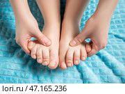 Woman giving herself foot massage, corns and calluses on feet, dry skin on legs. Стоковое фото, фотограф Станислав Тарко / Фотобанк Лори