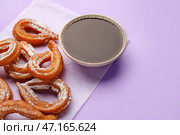 Пергамент с вкусными чуррос и расплавленным шоколадным соусом на цветном фоне, крупным планом. Стоковое фото, фотограф Pixel_shot / Фотобанк Лори