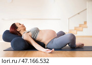 Pregnant woman is engaged in yoga. Reclined Bound Angle Pose or Supta Baddha Konasana. Стоковое фото, фотограф Татьяна Яцевич / Фотобанк Лори