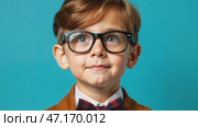 Little boy with glasses and bow tie on blue background. Portrait of intelligent child. Junior high student. Стоковое AI-видео, аниматор Ирина / Фотобанк Лори
