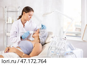 Aesthetician administering facial procedure on young woman using ultrasonic shovel. Стоковое фото, фотограф Яков Филимонов / Фотобанк Лори