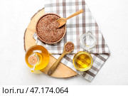 Деревянная доска с льняным маслом и семенами на светлом фоне. Стоковое фото, фотограф Pixel_shot / Фотобанк Лори