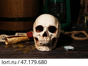 Человеческий череп с мечом, карманными часами, нефтяной лампой и монетами на коричневом деревянном фоне. Стоковое фото, фотограф Pixel_shot / Фотобанк Лори