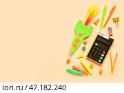 Бумажные ракеты цвета крема с калькулятором, ручками и циркулем на бежевом фоне. Стоковое фото, фотограф Pixel_shot / Фотобанк Лори