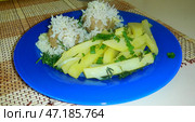 Картофель жареный и тефтели посыпанные зеленью на синей тарелке. Fried potatoes and meatballs sprinkled with herbs on a blue plate. 在蓝色盘子上撒上香草的炸土豆和肉丸。 Стоковое фото, фотограф Денис Баданин / Фотобанк Лори