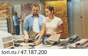 Married couple is interested in choosing softest and most beautiful carpet from the carpet samples. Стоковое видео, видеограф Яков Филимонов / Фотобанк Лори