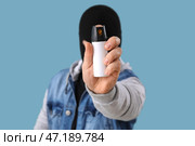Вор с перцовым баллончиком для самообороны на синем фоне, крупным планом. Стоковое фото, фотограф Pixel_shot / Фотобанк Лори