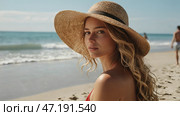 A woman on vacation, sitting in a swimsuit and a wide-brimmed straw hat on the beach on a sunny day and looking at the sea. Стоковое AI-изображение, AI-художник Photojuli / Фотобанк Лори