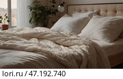 The interior of a modern house. A minimalistic cozy beige bedroom interior with a plaid, pillows, a headboard, linen linens and a bedside table. Стоковое AI-изображение, AI-художник Photojuli / Фотобанк Лори