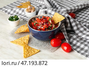 Чаша вкусной сальсы Пико де Галло и начос на столе. Стоковое фото, фотограф Pixel_shot / Фотобанк Лори