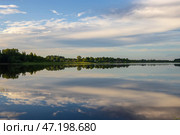 Красивый сельский пейзаж с озером. Облака отражаются в воде. Деревня у озера. Лето в сельской местности. Озеро Орлинское. Вдали село Орлино. Ленинградская область, Россия. Стоковое фото, фотограф Андрей Степанов / Фотобанк Лори