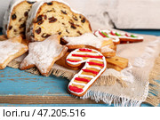 Доска с вкусным рождественским печеньем и штолленом на цветном деревянном столе, крупным планом. Стоковое фото, фотограф Pixel_shot / Фотобанк Лори