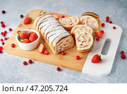 Разделочная доска с вкусным бисквитным рулетом и свежими ягодами на светлом столе. Стоковое фото, фотограф Pixel_shot / Фотобанк Лори