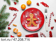 Композиция с тарелкой вкусных блинчиков с пряничным человечком, елочными украшениями и еловыми ветками на светлом фоне. Стоковое фото, фотограф Pixel_shot / Фотобанк Лори