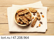 Салфетка с миской вкусного печенья бискотти, миндальными орехами и шоколадом на деревянном фоне. Стоковое фото, фотограф Pixel_shot / Фотобанк Лори