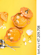 Горшочки с вкусным крем-супом из тыквы и специями на желтом фоне. Стоковое фото, фотограф Pixel_shot / Фотобанк Лори