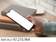 Женщина пользуется современным мобильным телефоном за столом, крупным планом. Стоковое фото, фотограф Pixel_shot / Фотобанк Лори