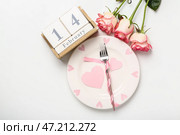 Кубический календарь с датой 14 ФЕВРАЛЯ, сервировкой стола и розами на белом фоне. Стоковое фото, фотограф Pixel_shot / Фотобанк Лори