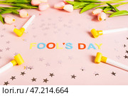 April Fools' Day written in colored letters, whistles, stars and tulips on pink. Стоковое фото, фотограф Елена Руй / Фотобанк Лори