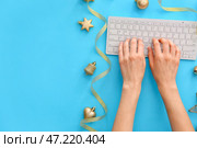 Руки с клавиатурой ПК и новогодним декором на цветном фоне. Стоковое фото, фотограф Pixel_shot / Фотобанк Лори