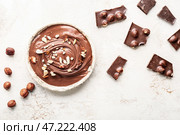 Чаша с вкусной шоколадной пастой и фундуком на светлом фоне. Стоковое фото, фотограф Pixel_shot / Фотобанк Лори