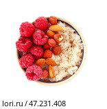 Чаша вкусного рисового пудинга с малиной и орехами на белом фоне. Стоковое фото, фотограф Pixel_shot / Фотобанк Лори