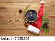 Новогодняя композиция с будильником и фигуркой 2021 на деревянном фоне. Стоковое фото, фотограф Pixel_shot / Фотобанк Лори