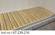 Assembling an ottoman. Installation of base, backrest, and handrails. Installed pull-out linen drawers. Стоковое видео, видеограф Vadzim Yakubovich / Фотобанк Лори
