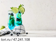 Бокалы вкусного голубого коктейля мохито на белом фоне. Стоковое фото, фотограф Pixel_shot / Фотобанк Лори