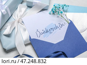 Открытка с текстом DANKE SCHON и подарочными коробками на столе крупным планом. Стоковое фото, фотограф Pixel_shot / Фотобанк Лори