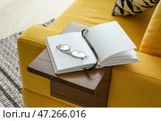 Очки и книга на столике на подлокотнике в номере. Стоковое фото, фотограф Pixel_shot / Фотобанк Лори