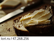 Slice of wholemeal bread with butter curl. Buttering toast. Yellow butter scattered on a piece of bread. Bread with toasting and spreading butter. Generous spread of butter on a rustic bread slice. Стоковое AI-изображение, AI-художник Марина Демидюк / Фотобанк Лори