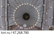 Beautiful ray-shaped chandelier in a Catholic church. Стоковое видео, видеограф Mikhail Davidovich / Фотобанк Лори
