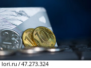 Пластиковая банковская карточка и рублевые монеты на клавиатуре компьютера. Редакционное фото, фотограф E. O. / Фотобанк Лори