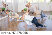 Positive boy and teens doing breakdance in dance hall with male trainer in choreography studio. Стоковое фото, фотограф Яков Филимонов / Фотобанк Лори