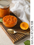 Деревянная доска с миской вкусного абрикосового варенья на светлом столе, крупным планом. Стоковое фото, фотограф Pixel_shot / Фотобанк Лори