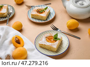 Тарелки с кусочками вкусного абрикосового пирога на цветном фоне. Стоковое фото, фотограф Pixel_shot / Фотобанк Лори