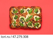 Вкусный итальянский пирог с моцареллой и соусом песто на красном фоне. Стоковое фото, фотограф Pixel_shot / Фотобанк Лори