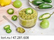 Чаша вкусного зеленого соуса сальса и перца халапеньо на светлом фоне. Стоковое фото, фотограф Pixel_shot / Фотобанк Лори