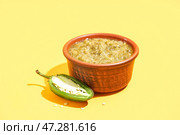 Чаша вкусного зеленого соуса сальса на желтом фоне. Стоковое фото, фотограф Pixel_shot / Фотобанк Лори
