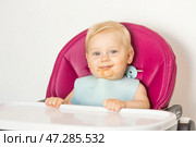 Baby food. The first meal. Feeding the baby. A cute little kid eats vegetables. Healthy food. The child is sitting on a high chair for feeding. Fresh vegetables and fruits. Стоковое фото, фотограф Photojuli / Фотобанк Лори