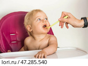 Baby food. The first meal. Feeding the baby. A cute little kid eats vegetables. Healthy food. The child is sitting on a high chair for feeding. Fresh vegetables and fruits. Стоковое фото, фотограф Photojuli / Фотобанк Лори