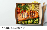 Grilled salmon with quinoa and vegetables on a white background served in a takeout box. Лосось на гриле с киноа и овощами на белом фоне, поданный в коробке на вынос. Стоковое AI-изображение, AI-художник Katsiaryna Repich / Фотобанк Лори