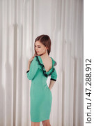 Model Poses in a Stylish Mint Green Dress Showcasing Elegance in a Studio Setting. Стоковое фото, фотограф Aleksandr Golubev / Фотобанк Лори